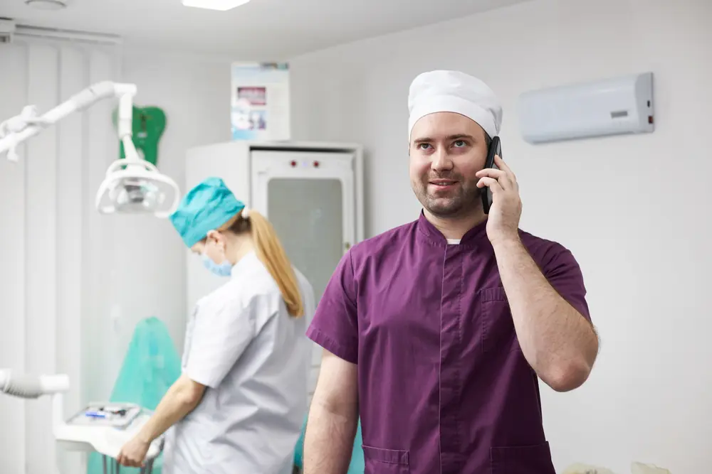 Dentist taking a phone call in a dental clinic