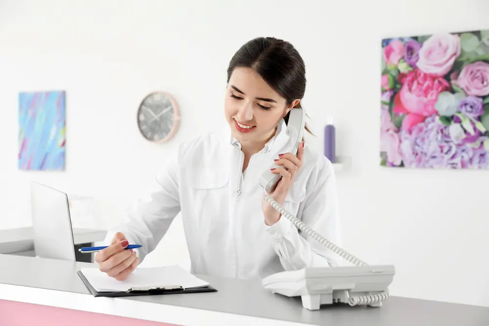 Receptionist answering a phone call at a business front desk